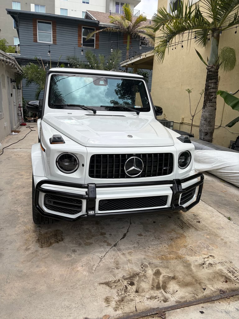 White Mercedes-Benz G-Class SUV parked in a residential driveway